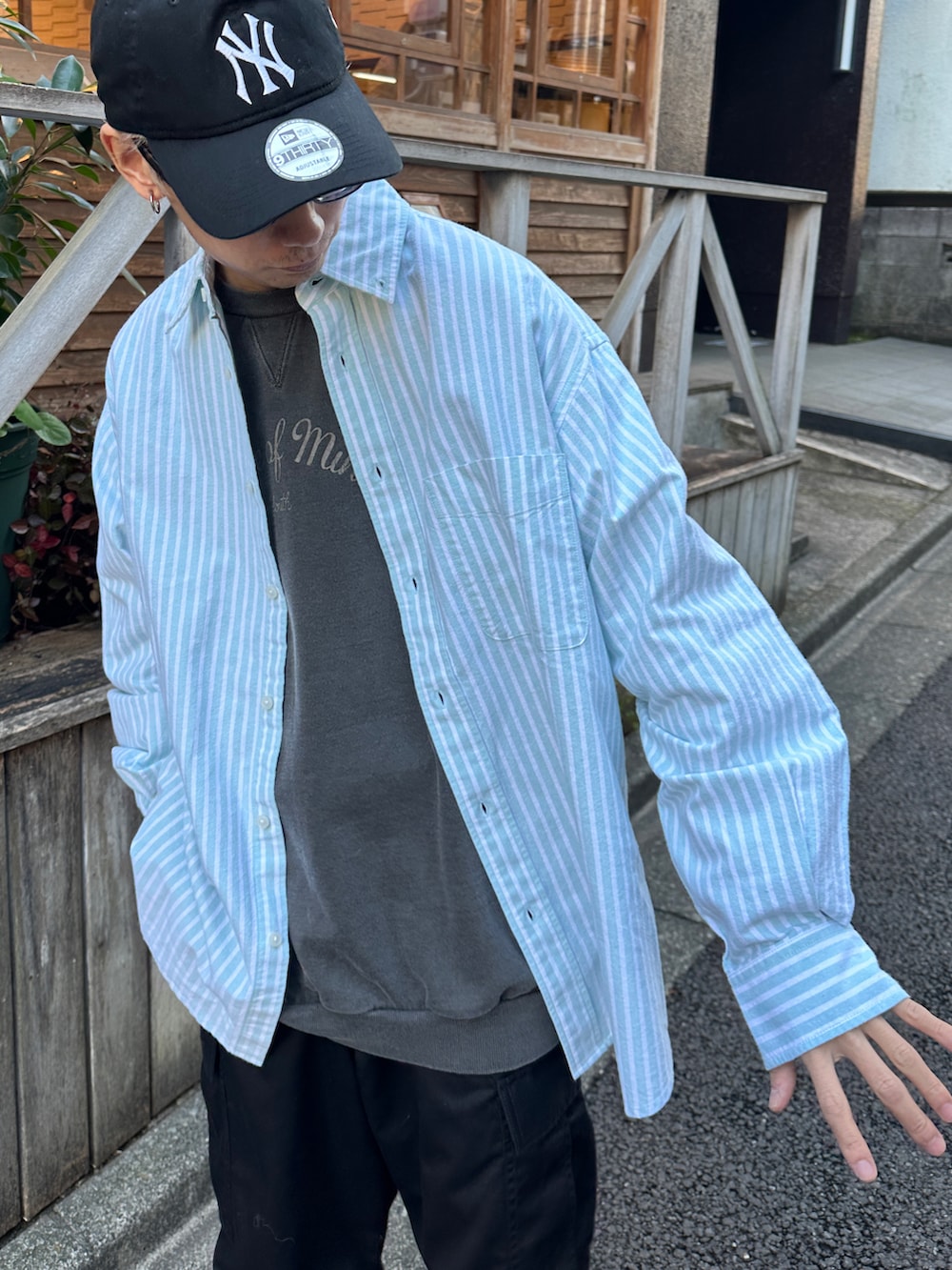 グリーン系のシャツ/ブラウス、ブラック系のスウェット、ホワイト系のスニーカーを着用したメンズの冬コーディネートの5枚目の写真