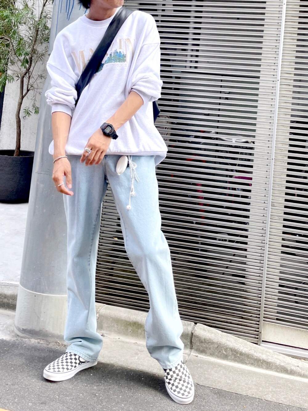 ホワイト系のタンクトップ、ブルー系のデニムパンツ、その他のスリッポンを着用したメンズの秋コーディネートの3枚目の写真