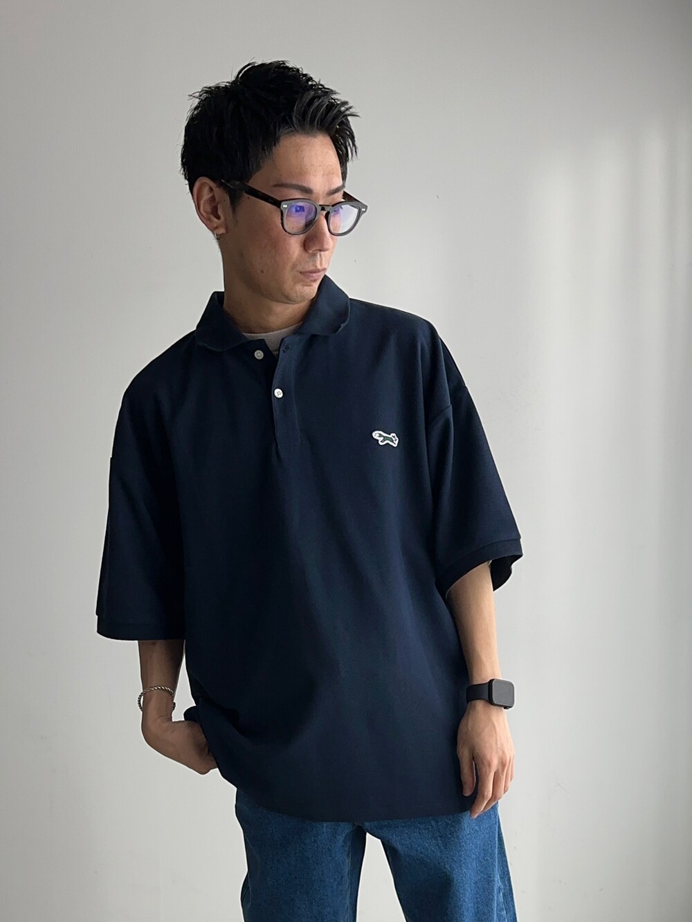 ブルー系のポロシャツ、グレー系のTシャツ/カットソー、ブルー系のデニムパンツを着用したメンズの春コーディネートの4枚目の写真