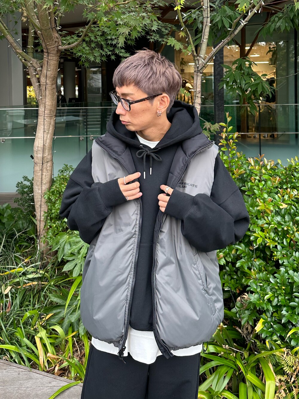 ブラック系のダウンベスト、ブラック系のパーカー、ホワイト系のスニーカーを着用したメンズの秋コーディネートの3枚目の写真