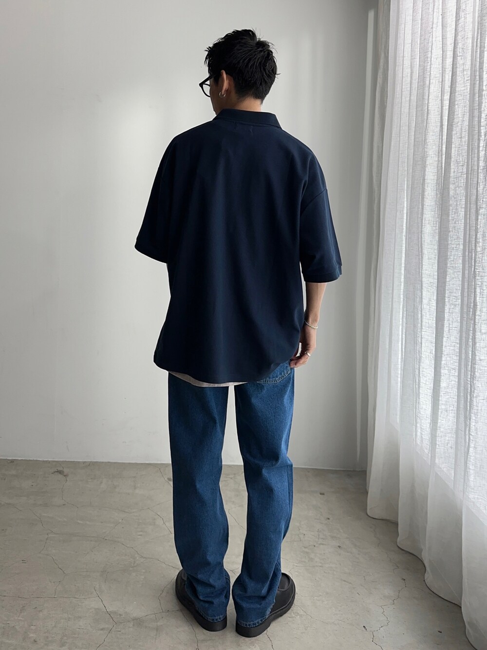 ブルー系のポロシャツ、グレー系のTシャツ/カットソー、ブルー系のデニムパンツを着用したメンズの春コーディネートの3枚目の写真