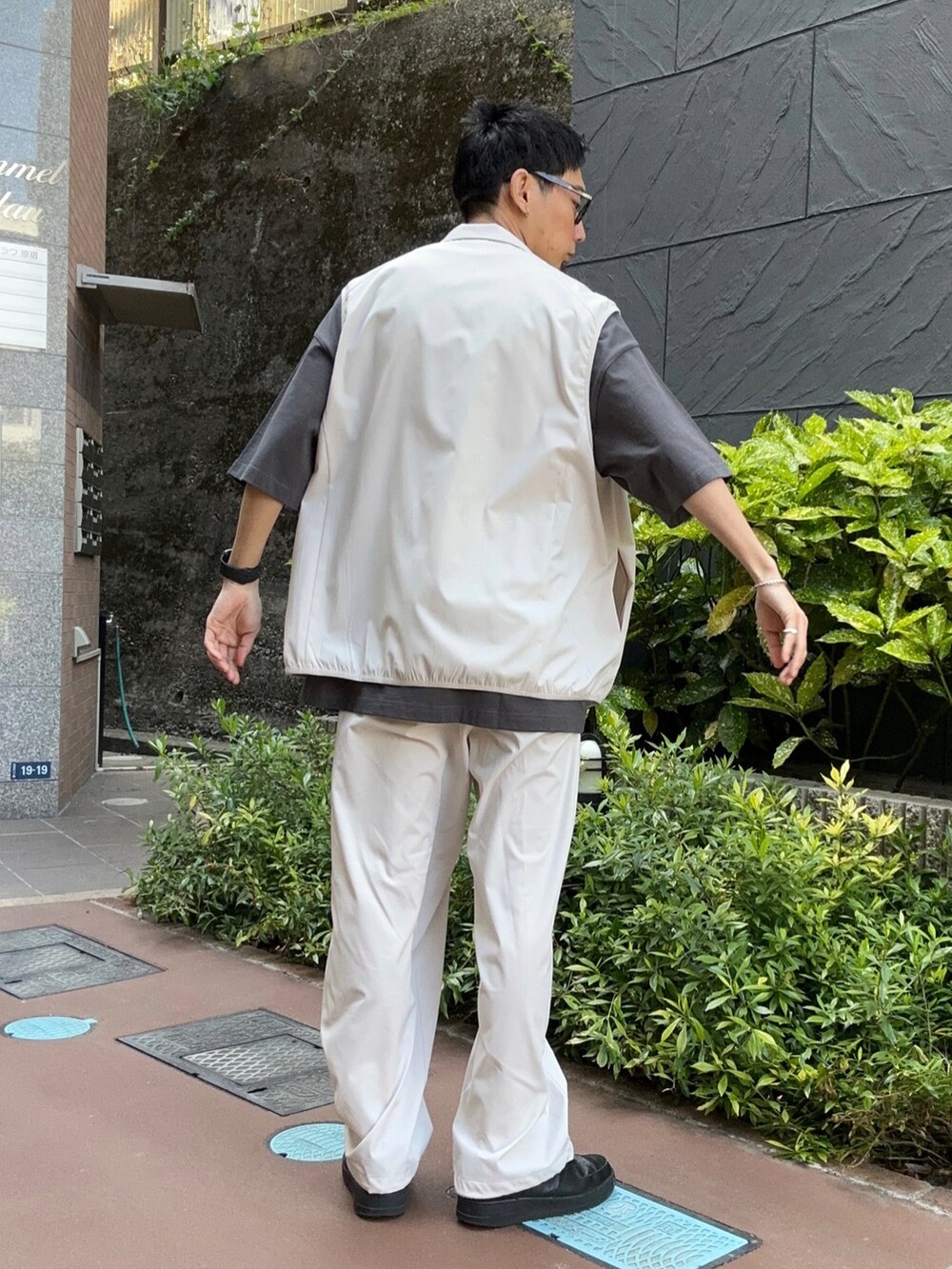 グレー系のベスト、ブラック系のTシャツ/カットソー、グレー系のスウェットパンツを着用したメンズの春コーディネートの2枚目の写真