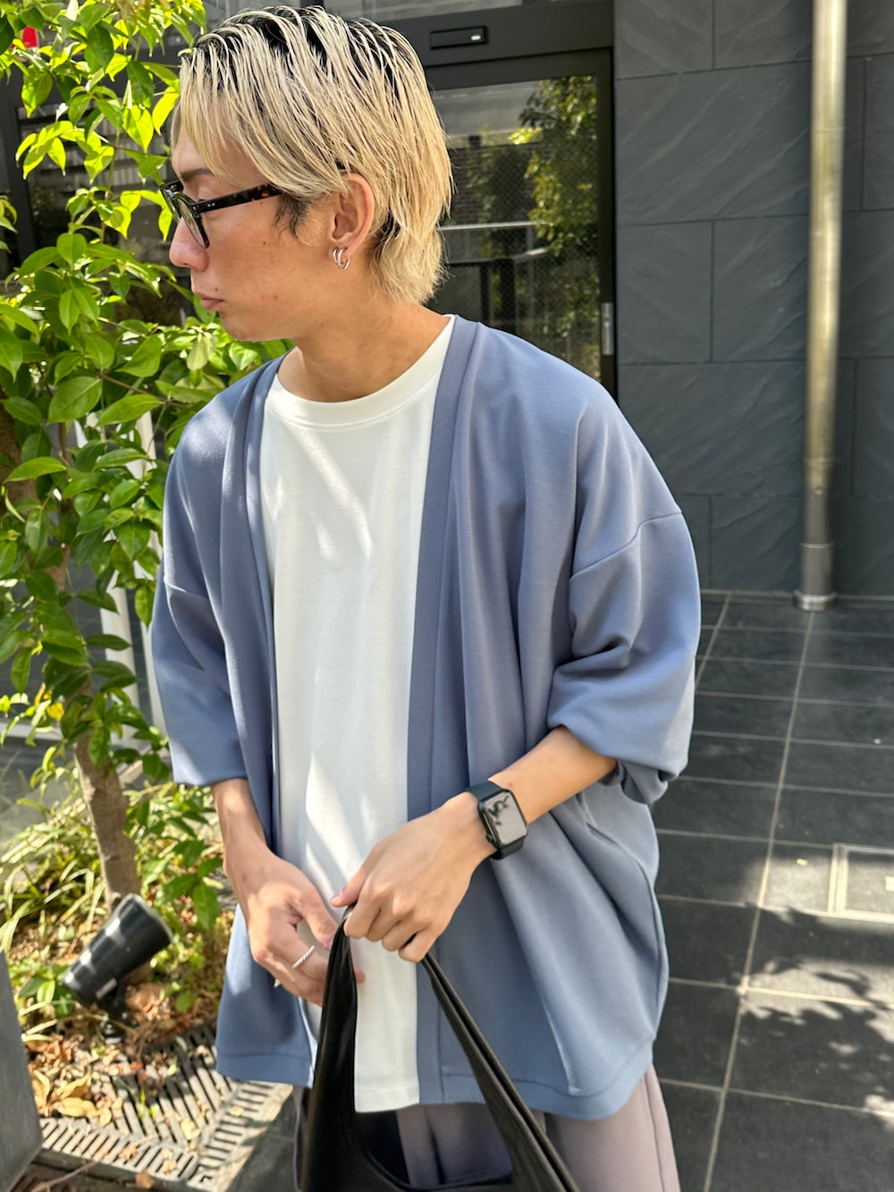 ブルー系のアンサンブル、パープル系のスラックス、ブラック系のトートバッグを着用したメンズの春コーディネートの4枚目の写真