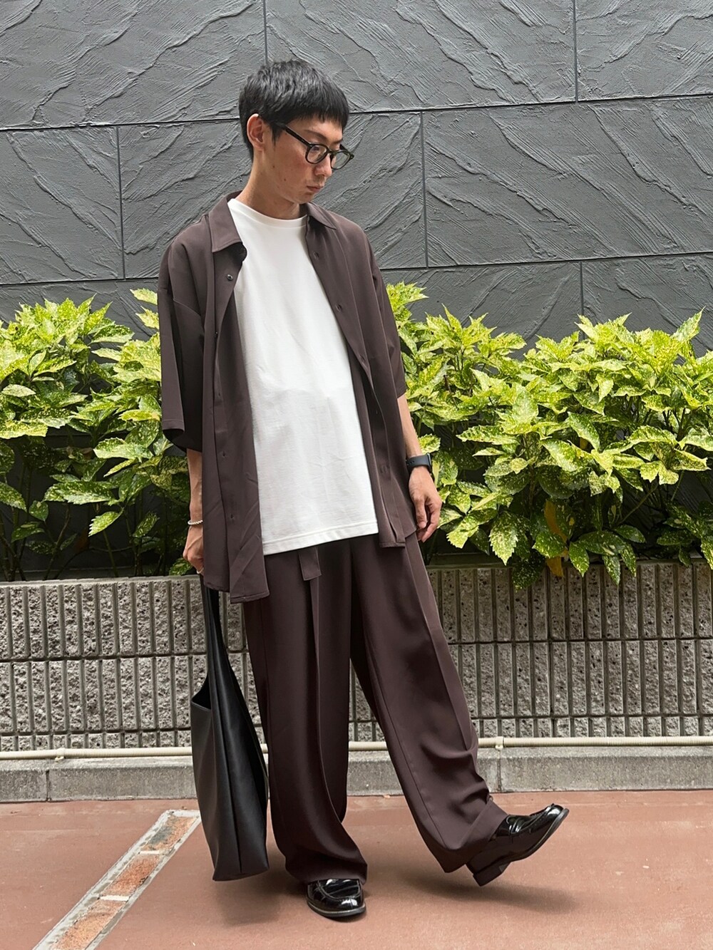 ブラック系のトートバッグ、ホワイト系のTシャツ/カットソー、ブラウン系のシャツ/ブラウスを着用したメンズの夏コーディネートの2枚目の写真
