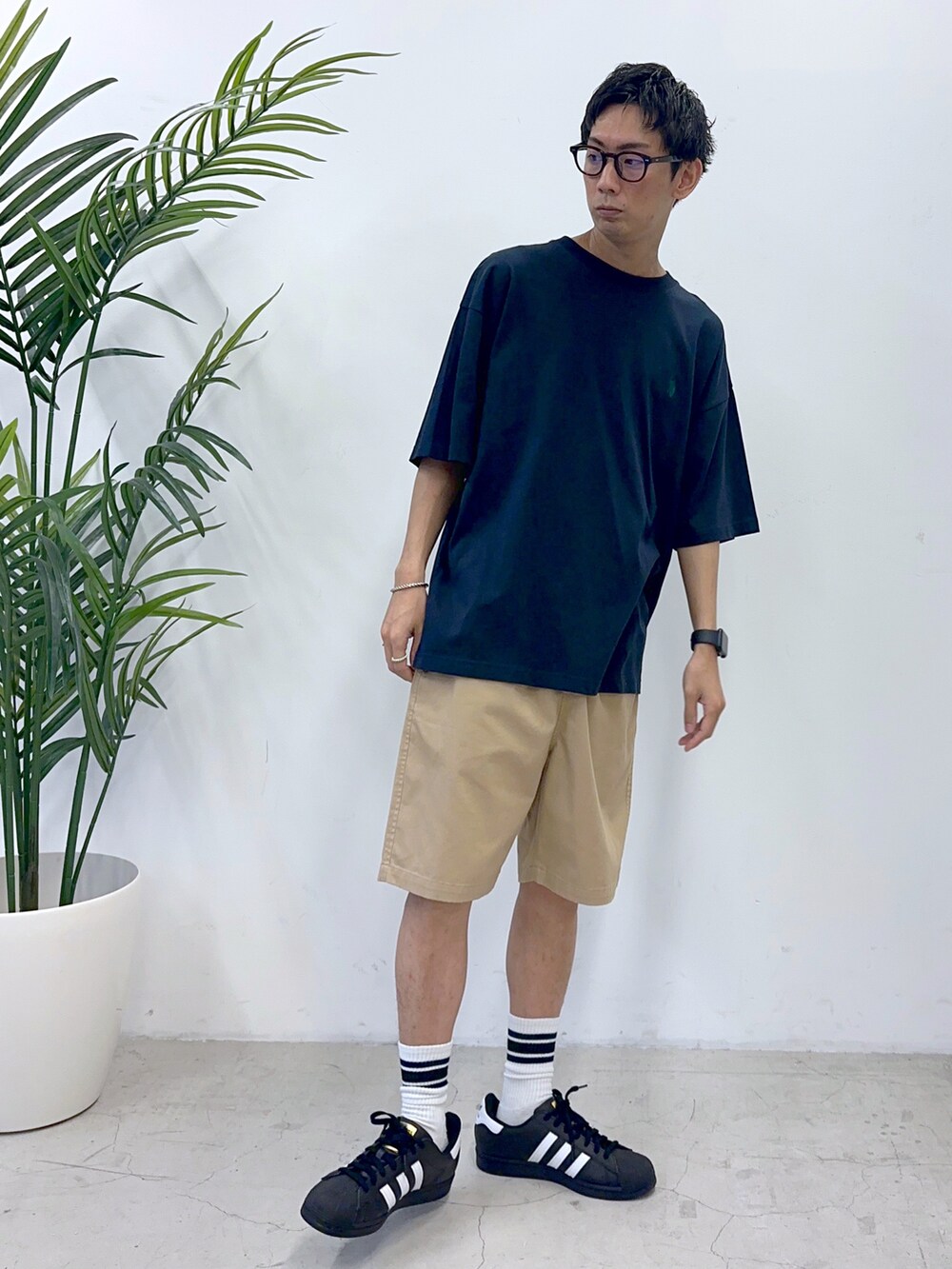 ブルー系のTシャツ/カットソー、ブラック系のスニーカー、ベージュ系のチノパンツを着用したメンズの夏コーディネートの3枚目の写真