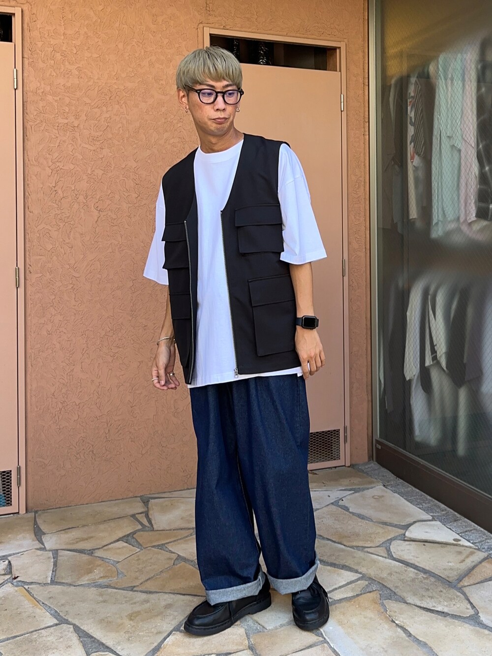 ブラック系のベスト、ブルー系のデニムパンツ、ホワイト系のTシャツ/カットソーを着用したメンズの夏コーディネートの2枚目の写真