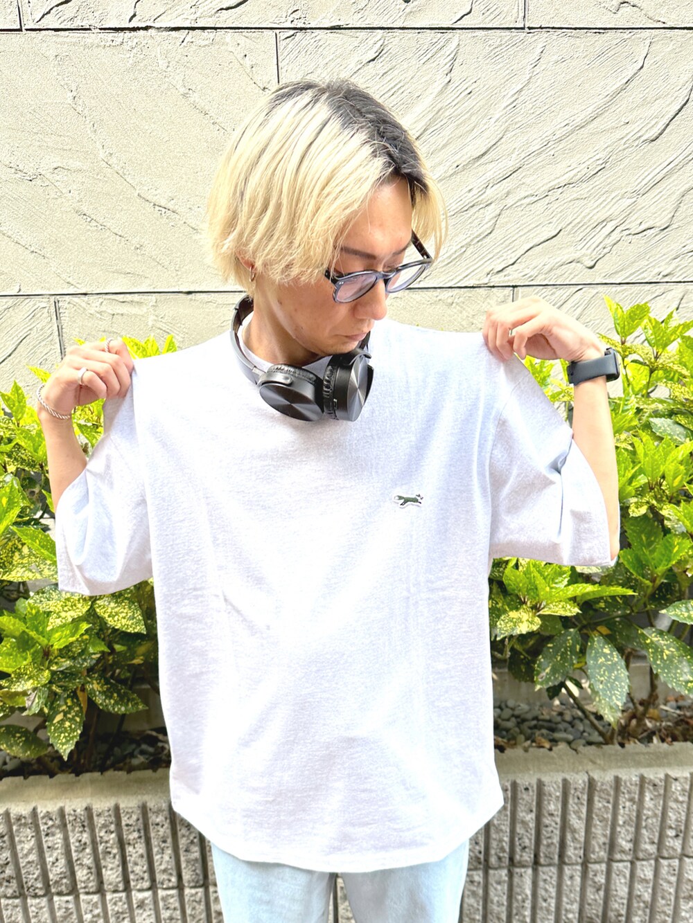 ブルー系のデニムパンツ、ホワイト系のスニーカー、グレー系のTシャツ/カットソーを着用したメンズの春コーディネートの4枚目の写真