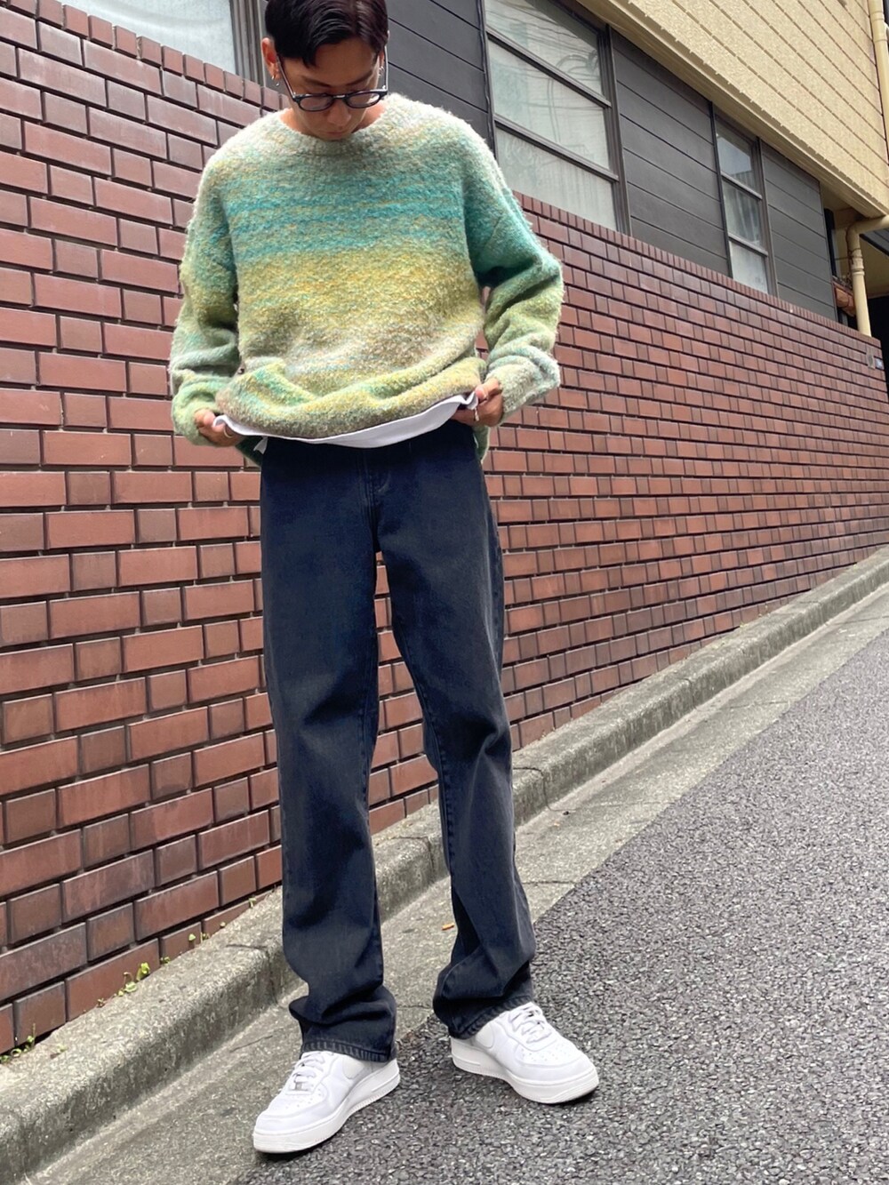 グリーン系のニット/セーター、ホワイト系のタンクトップ、ブラック系のデニムパンツを着用したメンズの秋コーディネートの2枚目の写真