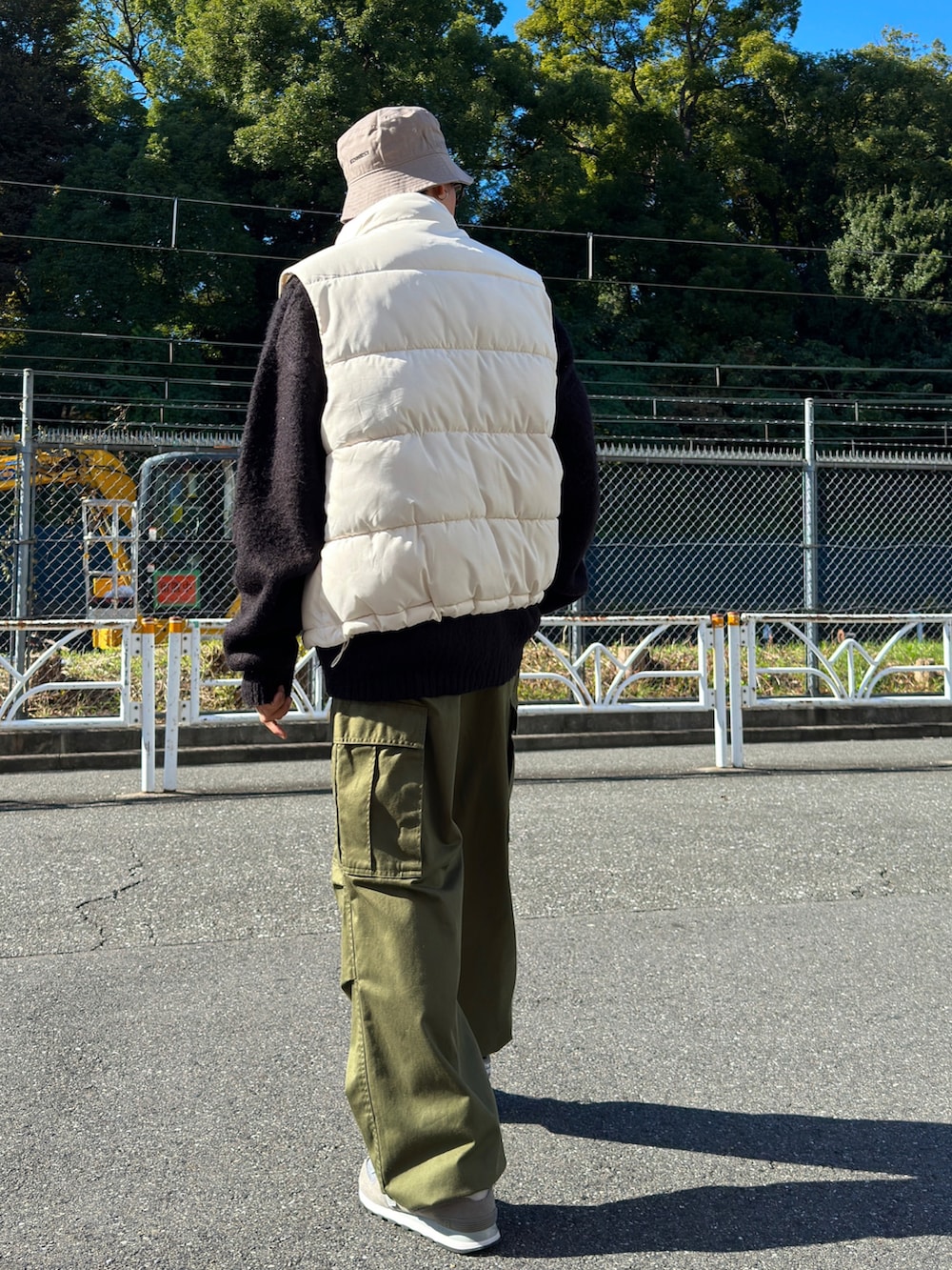 ホワイト系のダウンベスト、ブラック系のカーディガン/ボレロ、グレー系のスウェットを着用したメンズの秋コーディネートの3枚目の写真