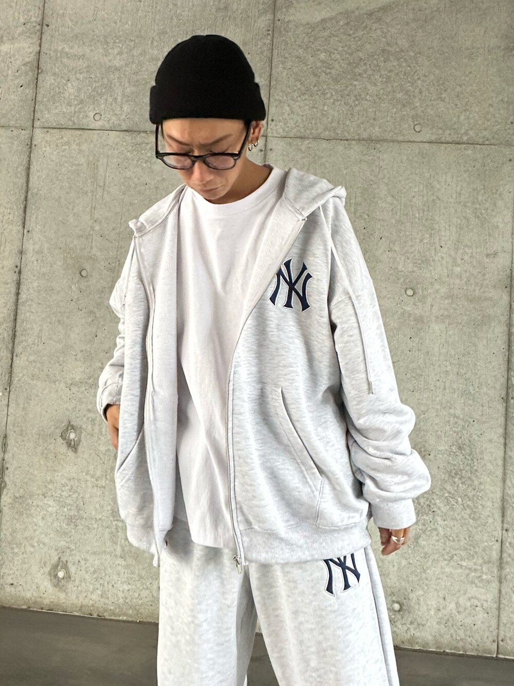 グレー系のパーカー、ホワイト系のTシャツ/カットソー、グレー系のスウェットパンツを着用したメンズの秋コーディネートの5枚目の写真