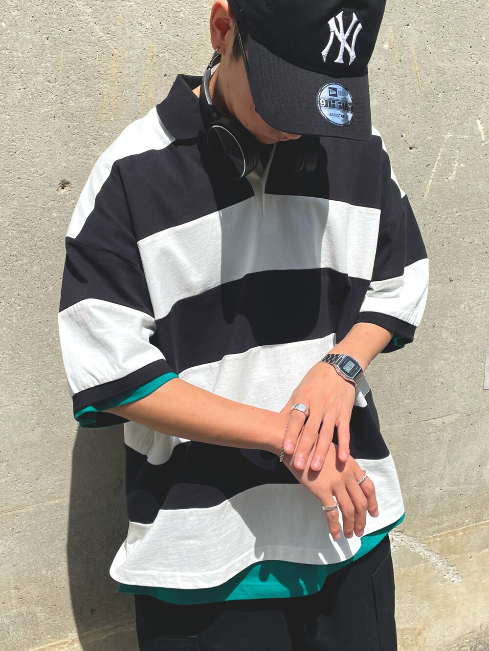 ブラック系のカーゴパンツ、ホワイト系のポロシャツを着用したメンズの春コーディネートの2枚目の写真