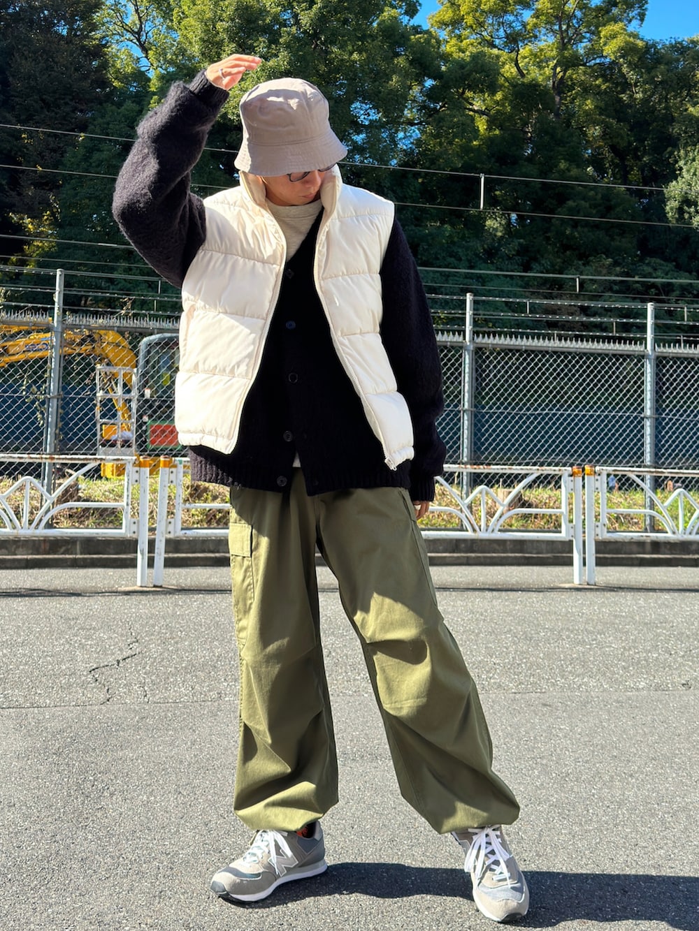 ホワイト系のダウンベスト、ブラック系のカーディガン/ボレロ、グレー系のスウェットを着用したメンズの秋コーディネートの2枚目の写真