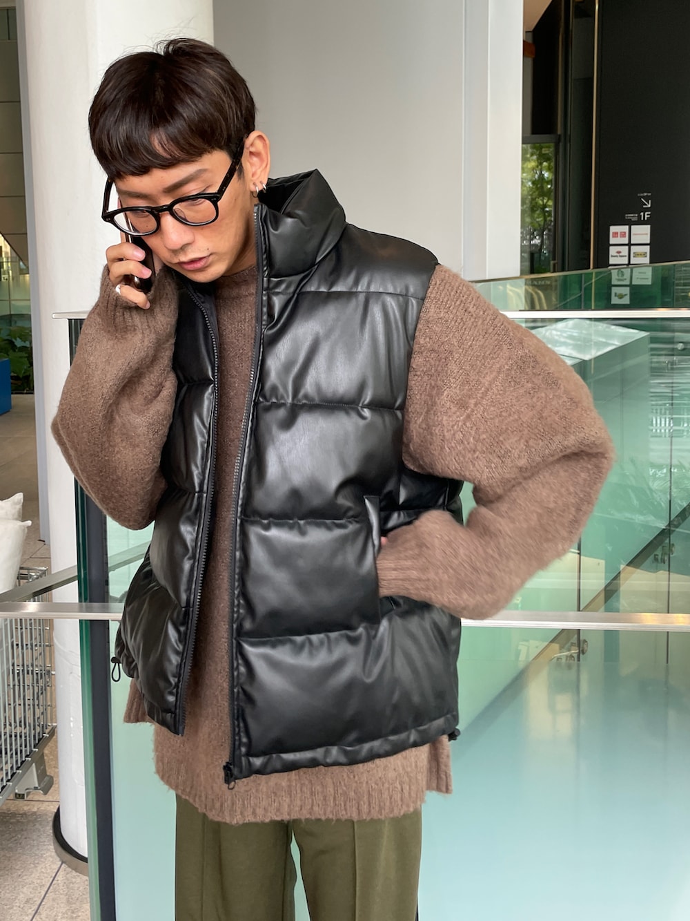 ブラック系のダウンベスト、ブラウン系のニット/セーター、グリーン系のスウェットパンツを着用したメンズの秋コーディネートの5枚目の写真