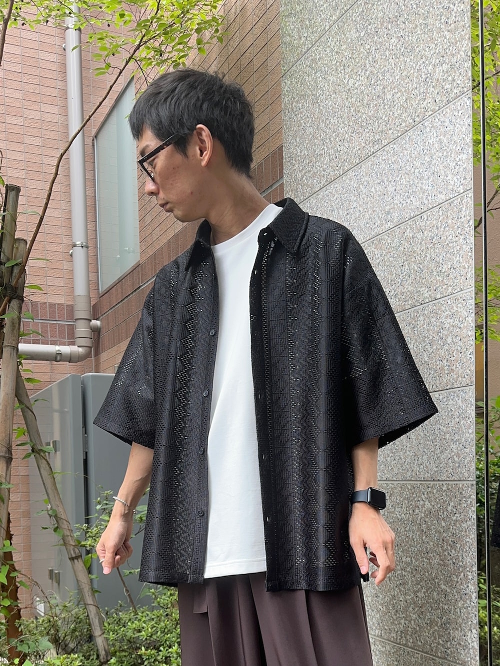 ブラック系のシャツ/ブラウス、ホワイト系のTシャツ/カットソー、ブラウン系のスラックスを着用したメンズの夏コーディネートの4枚目の写真