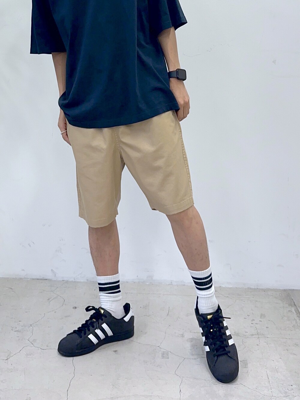 ブルー系のTシャツ/カットソー、ブラック系のスニーカー、ベージュ系のチノパンツを着用したメンズの夏コーディネートの5枚目の写真