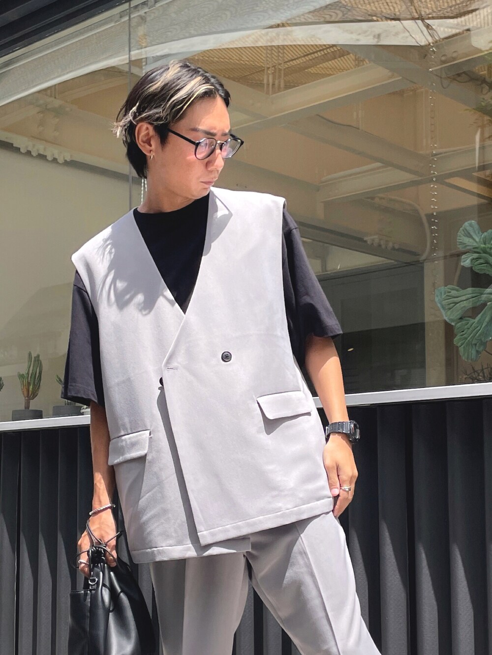 グレー系のベスト、ブラック系のTシャツ/カットソー、グレー系のスラックスを着用したメンズの夏コーディネートの2枚目の写真