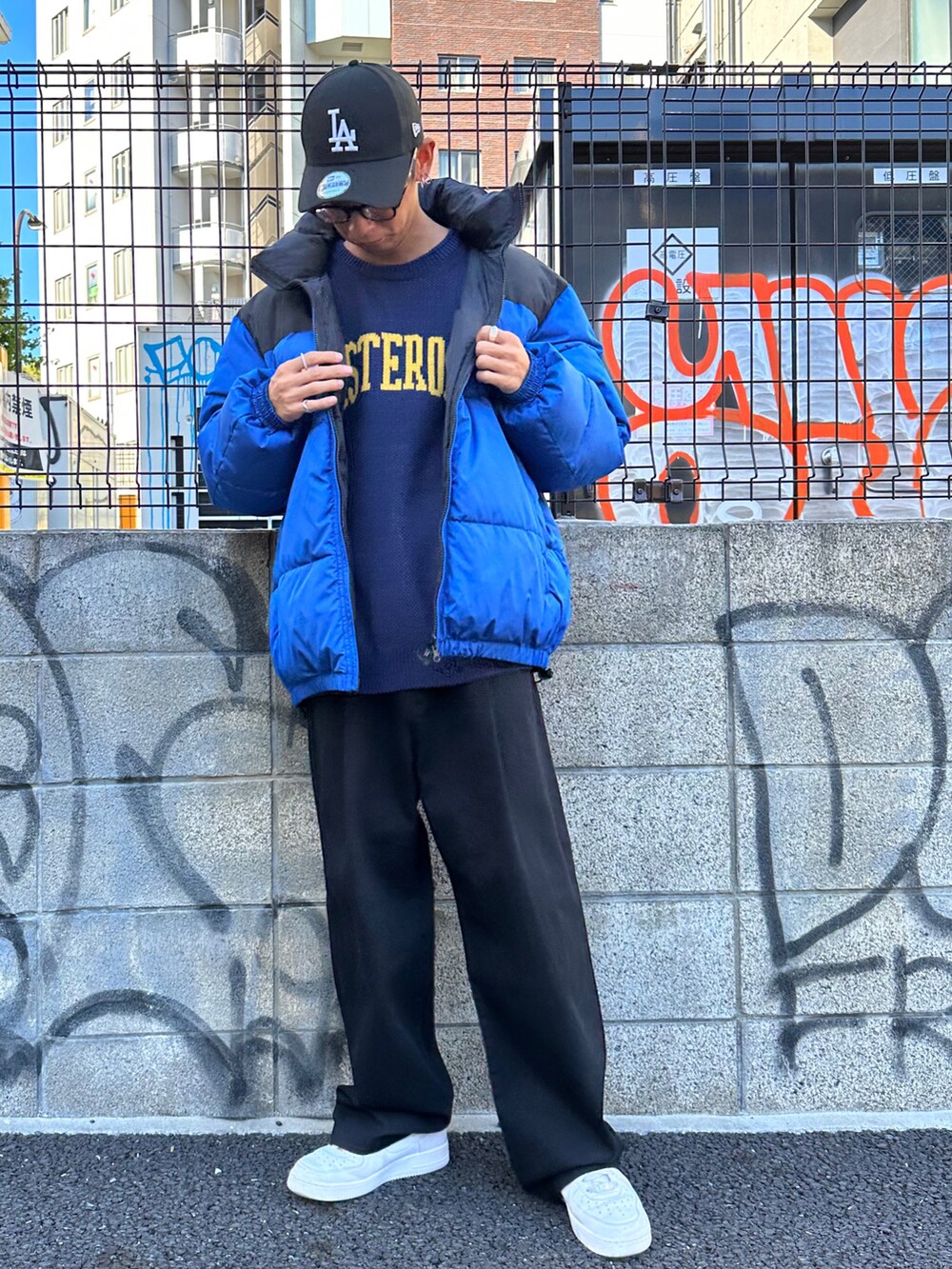 ブルー系のダウンジャケット/コート、ブルー系のニット/セーター、ブラック系のチノパンツを着用したメンズの秋コーディネートの2枚目の写真