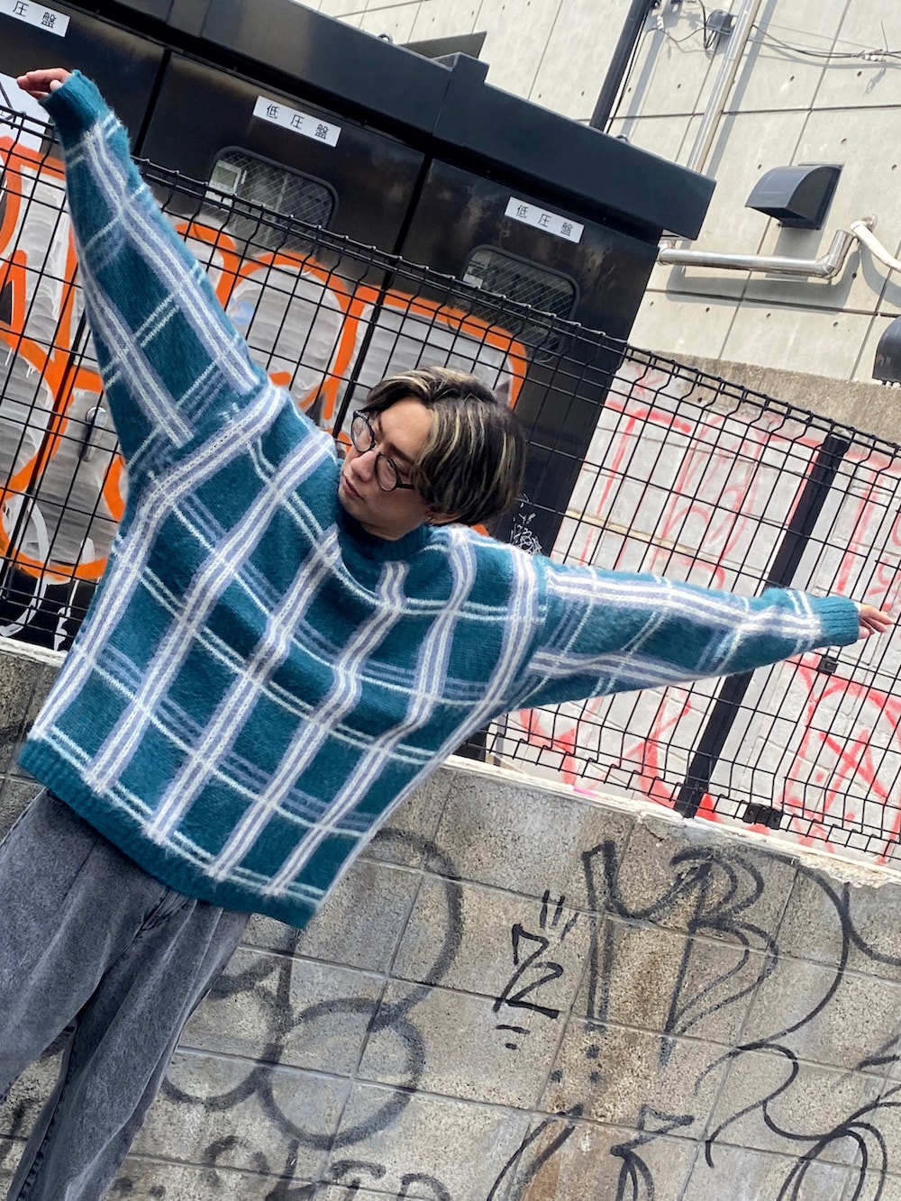 その他のニット/セーター、ブラック系のチノパンツ、ホワイト系のスニーカーを着用したメンズの夏コーディネートの2枚目の写真