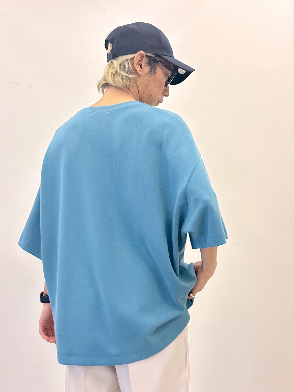 ブルー系のTシャツ/カットソー、ホワイト系のスラックス、その他のキャップを着用したメンズの春コーディネートの4枚目の写真