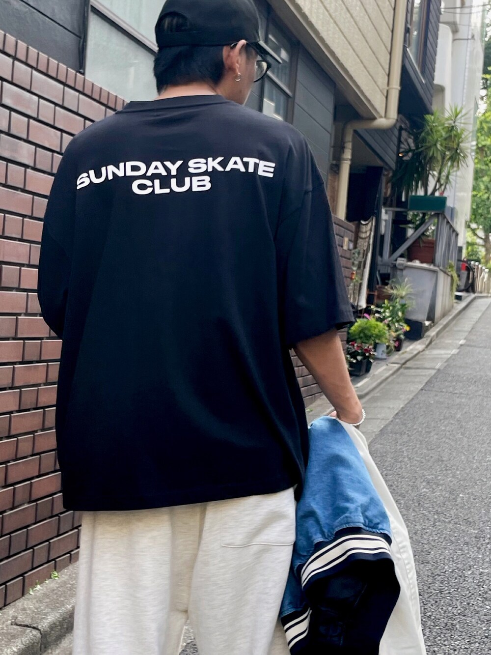 ブルー系のスタジャン、グレー系のスウェットパンツ、ホワイト系のスニーカーを着用したメンズの夏コーディネートの3枚目の写真