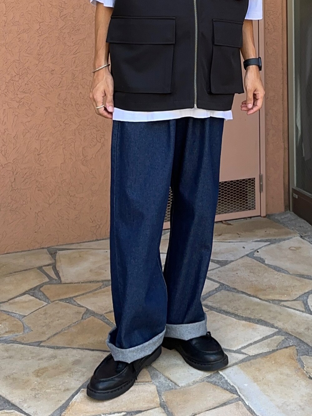 ブラック系のベスト、ブルー系のデニムパンツ、ホワイト系のTシャツ/カットソーを着用したメンズの夏コーディネートの5枚目の写真