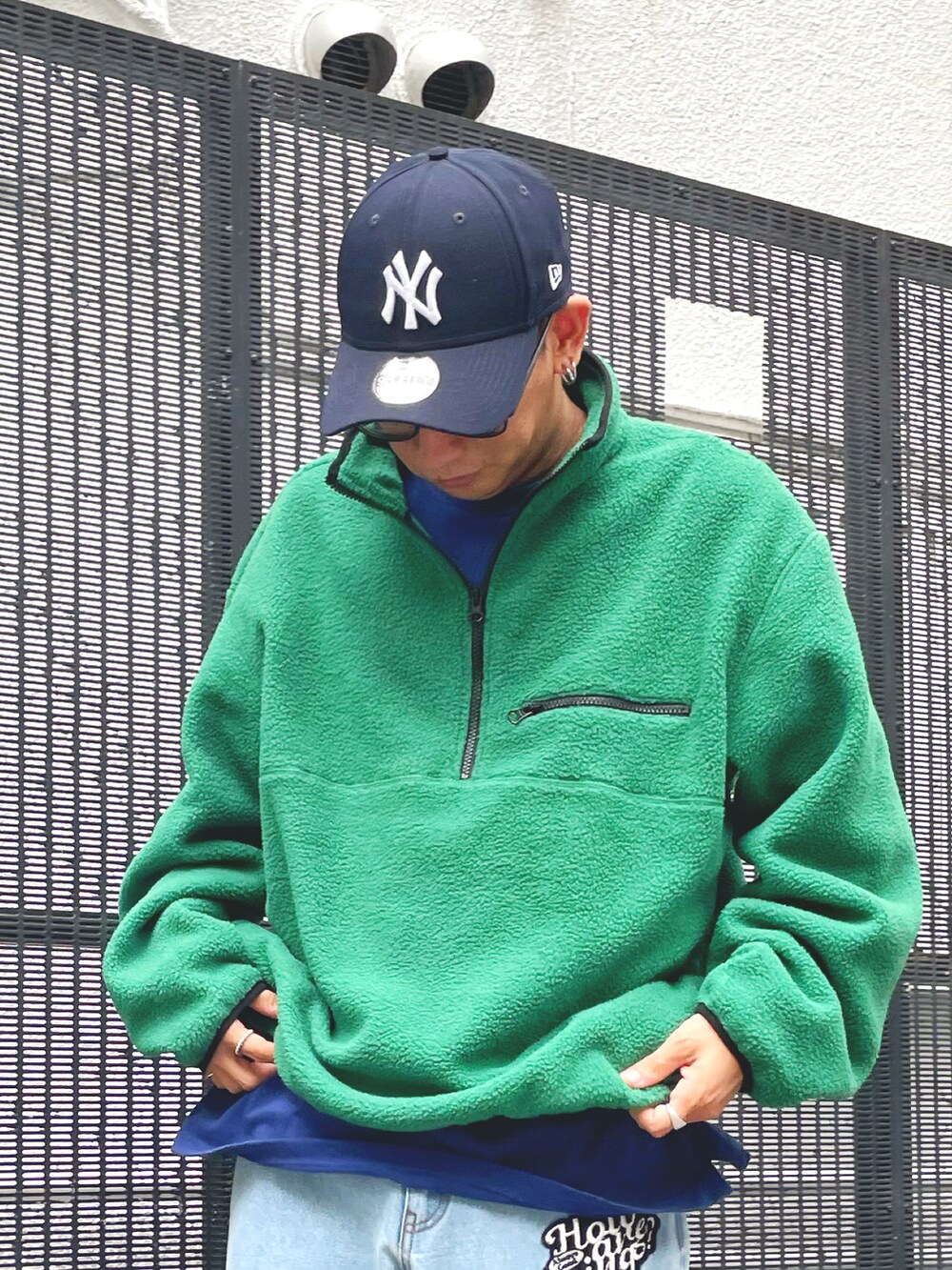 グリーン系のスウェット、ブルー系のデニムパンツ、ブルー系のキャップを着用したメンズの夏コーディネートの2枚目の写真