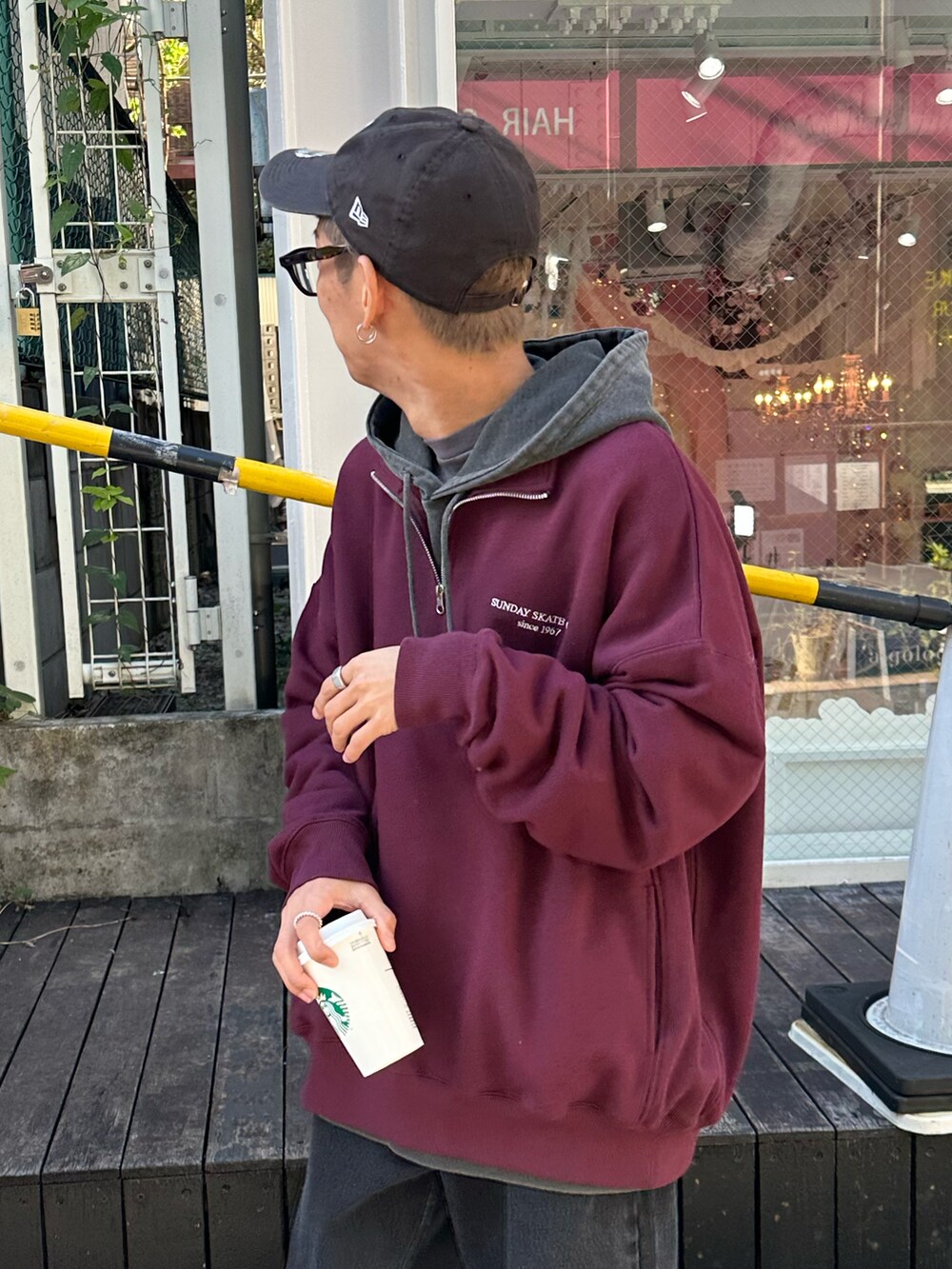 レッド系のスウェット、ブラック系のデニムパンツ、ブラック系のTシャツ/カットソーを着用したメンズの秋コーディネートの5枚目の写真