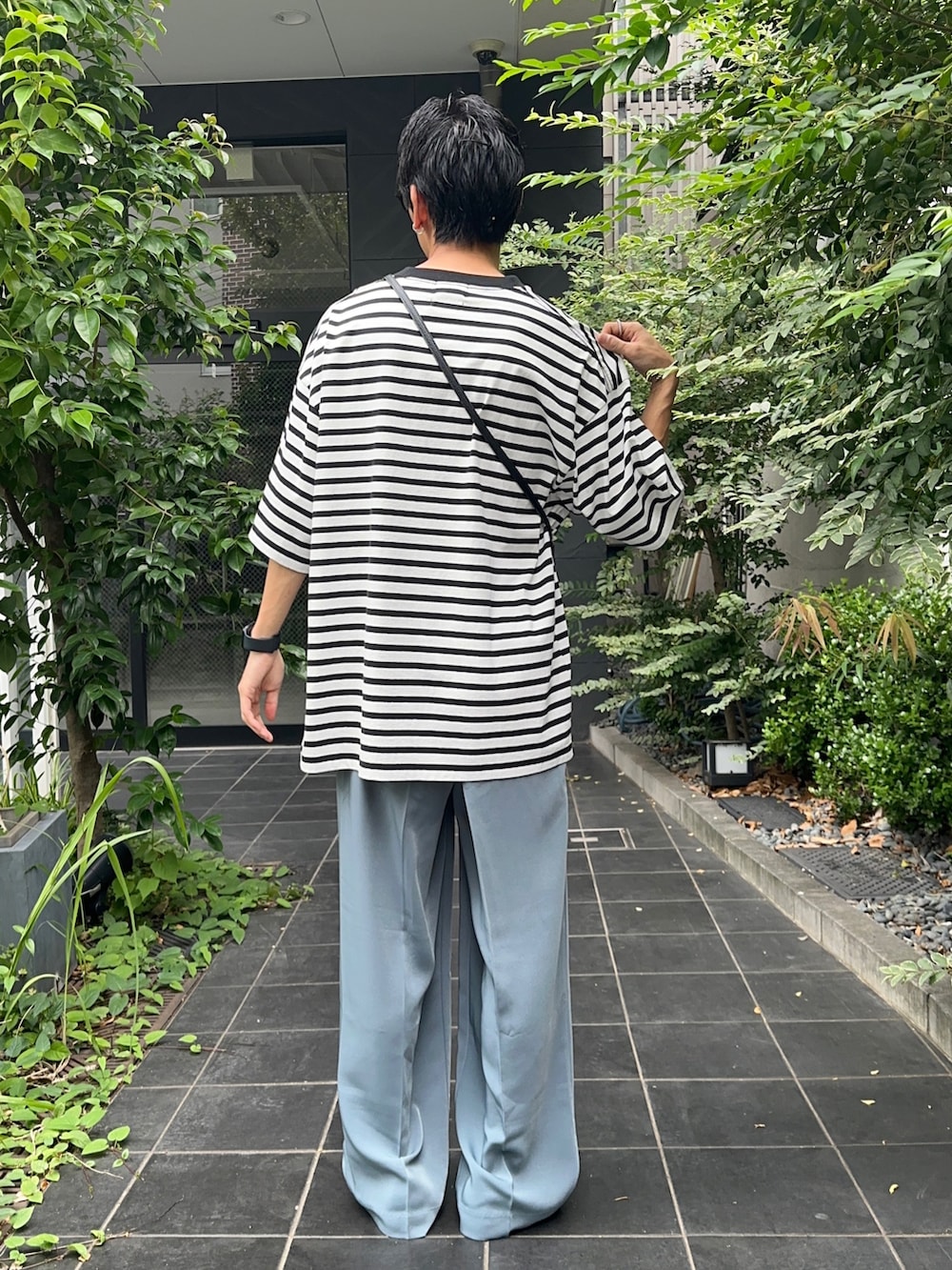 ホワイト系のTシャツ/カットソー、ブルー系のスラックスを着用したメンズの夏コーディネートの3枚目の写真