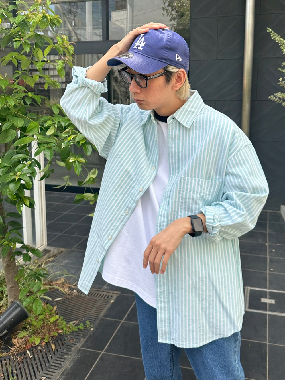 グリーン系のシャツ/ブラウス、その他のTシャツ/カットソー、ブルー系のデニムパンツを着用したメンズの春コーディネートの4枚目の写真