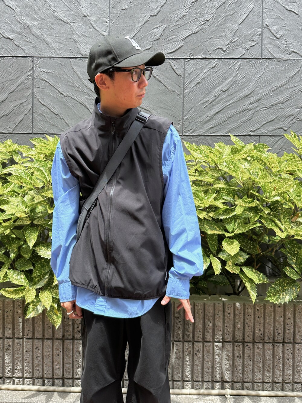 ブラック系のベスト、ブルー系のシャツ/ブラウス、ブラック系のカーゴパンツを着用したメンズの夏コーディネートの4枚目の写真