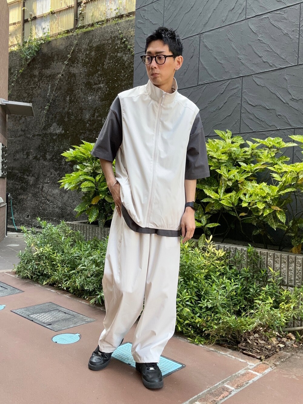 グレー系のベスト、ブラック系のTシャツ/カットソー、グレー系のスウェットパンツを着用したメンズの春コーディネートの3枚目の写真