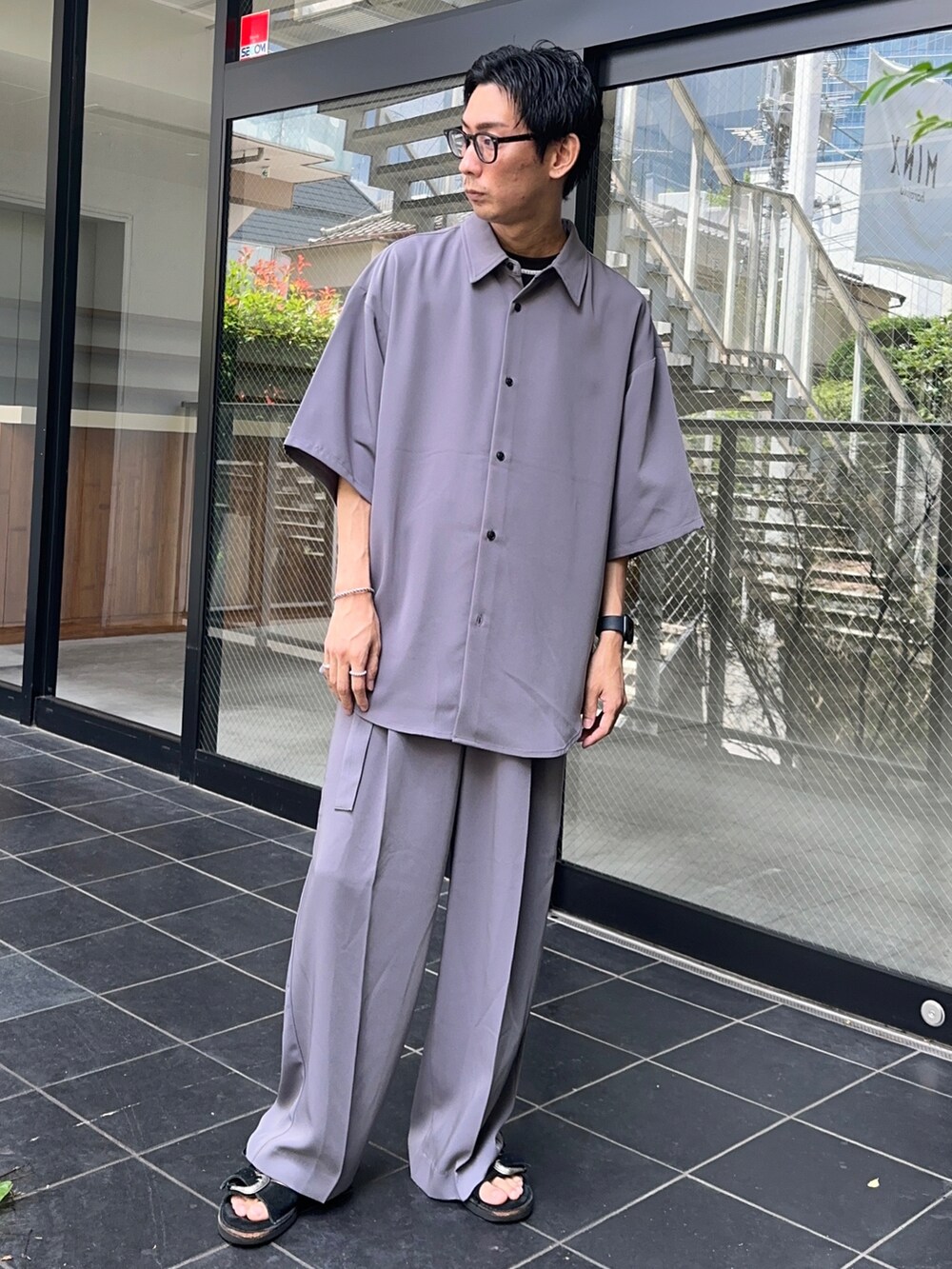 パープル系のシャツ/ブラウス、ブラック系のTシャツ/カットソー、パープル系のスラックスを着用したメンズの夏コーディネートの5枚目の写真
