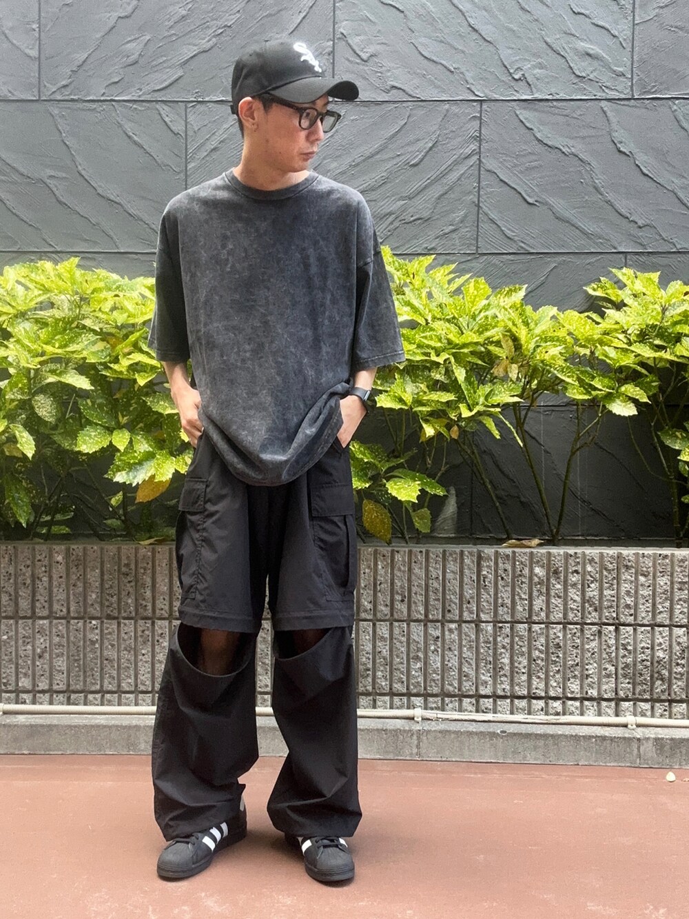 その他のTシャツ/カットソー、ブラック系のスニーカー、ブラック系のカーゴパンツを着用したメンズの春コーディネートの2枚目の写真