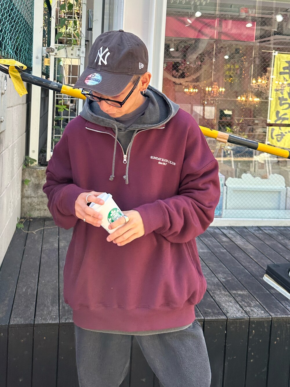 レッド系のスウェット、ブラック系のデニムパンツ、ブラック系のTシャツ/カットソーを着用したメンズの秋コーディネートの4枚目の写真