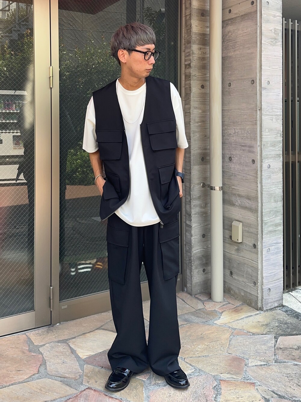 ホワイト系のTシャツ/カットソー、ブラック系のベスト、ブラック系のカーゴパンツを着用したメンズの夏コーディネートの2枚目の写真