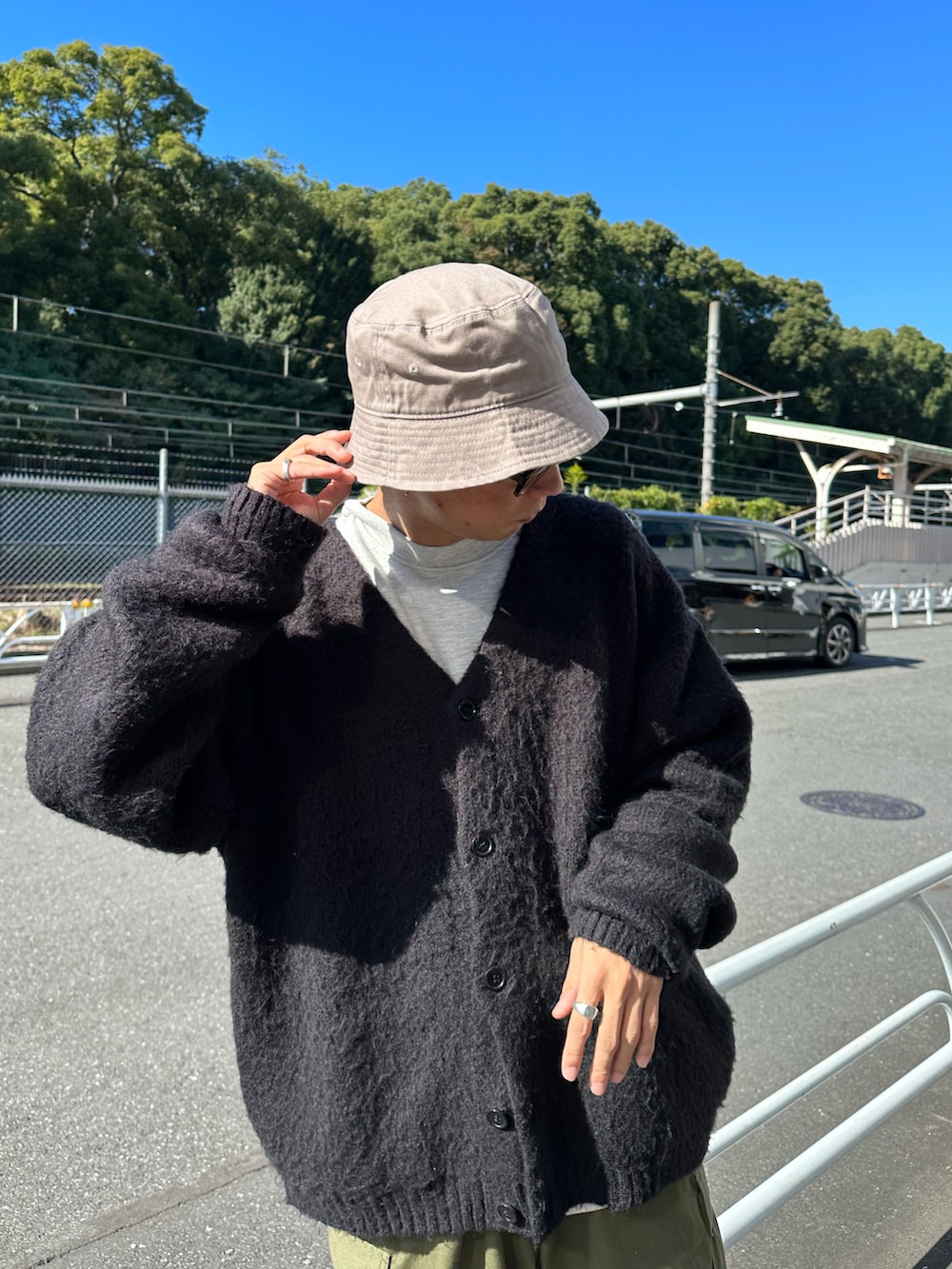 ホワイト系のダウンベスト、ブラック系のカーディガン/ボレロ、グレー系のスウェットを着用したメンズの秋コーディネートの4枚目の写真