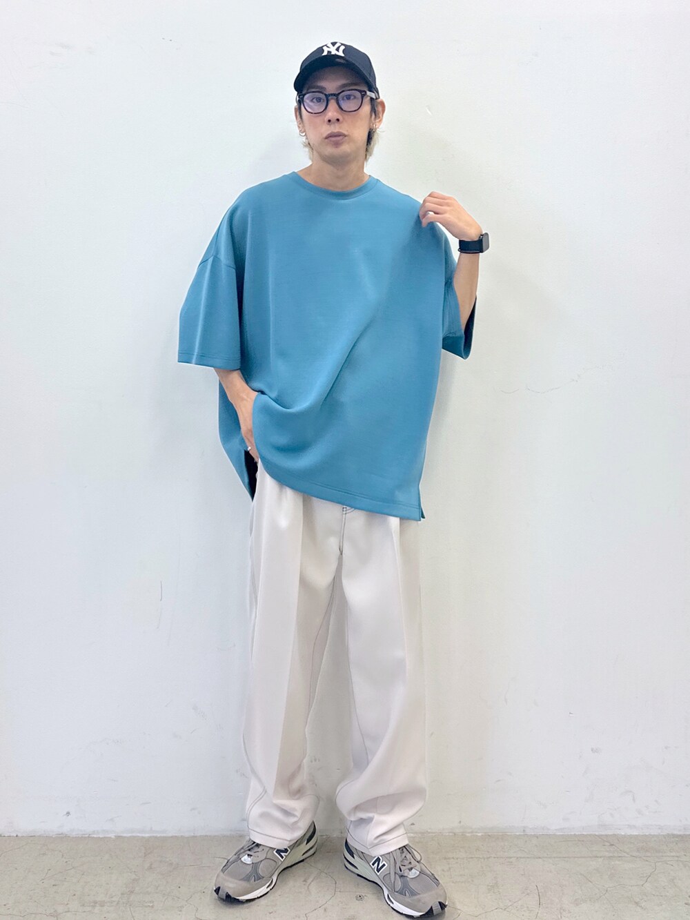 ブルー系のTシャツ/カットソー、ホワイト系のスラックス、その他のキャップを着用したメンズの春コーディネートの2枚目の写真