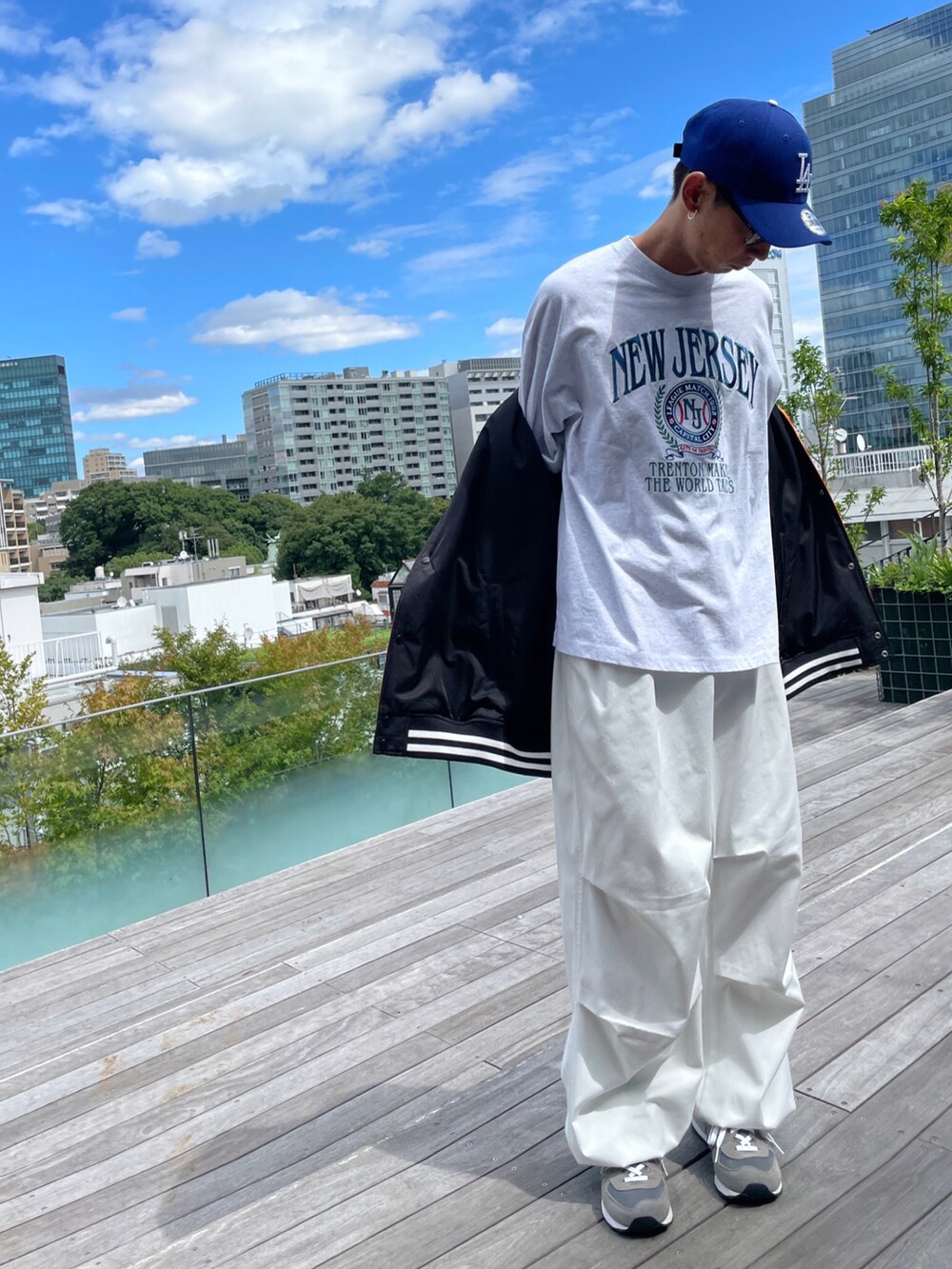 オレンジ系のスタジャン、グレー系のTシャツ/カットソー、ホワイト系のカーゴパンツを着用したメンズの秋コーディネートの4枚目の写真