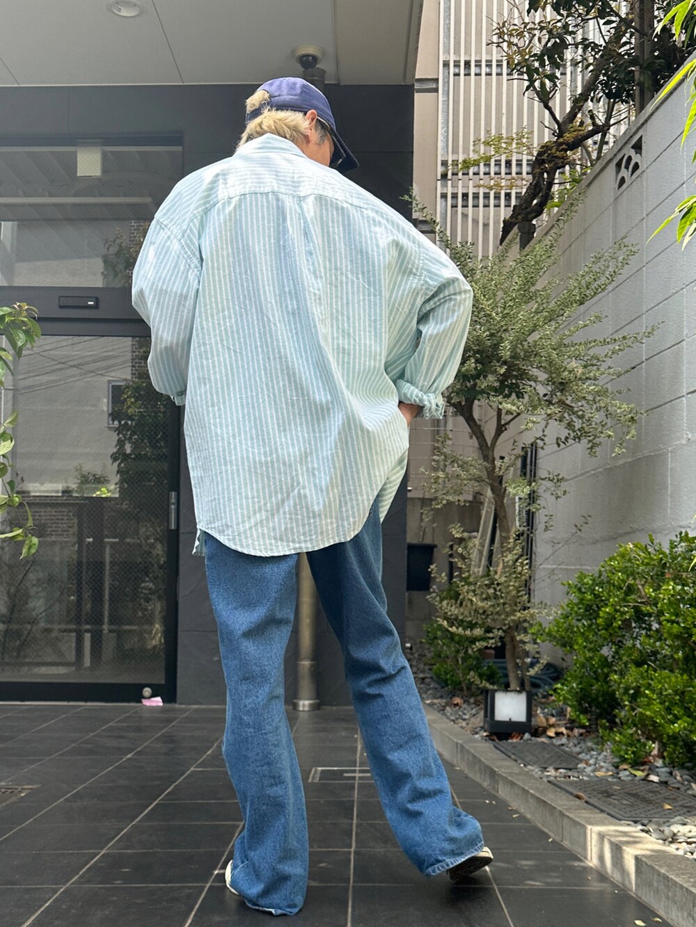 グリーン系のシャツ/ブラウス、その他のTシャツ/カットソー、ブルー系のデニムパンツを着用したメンズの春コーディネートの2枚目の写真