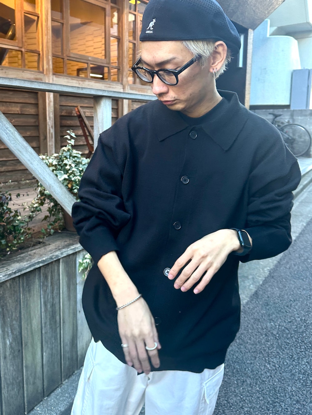 ブラック系のカーディガン/ボレロ、ホワイト系のカーゴパンツ、ブラック系のスニーカーを着用したメンズの冬コーディネートの3枚目の写真