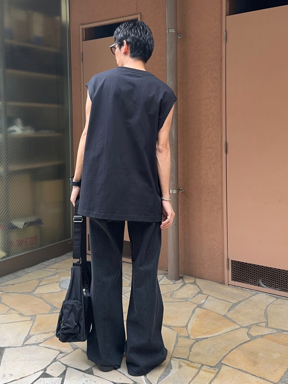 その他のタンクトップ、ブラック系のデニムパンツ、ブラック系のショルダーバッグを着用したメンズの夏コーディネートの3枚目の写真