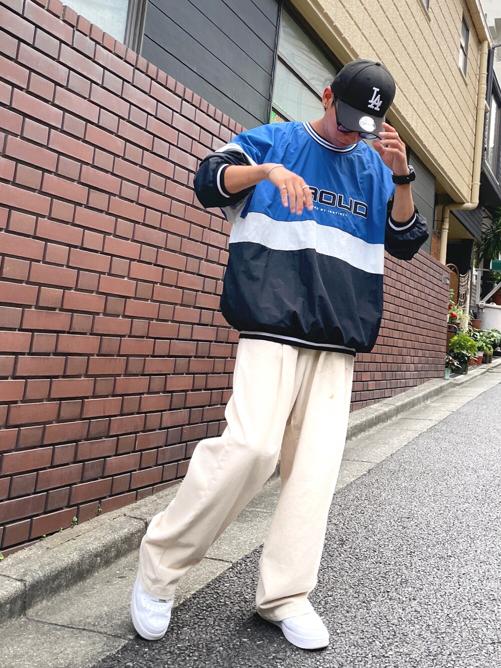 ベージュ系のチノパンツ、ホワイト系のスニーカー、ブルー系のスウェットを着用したメンズの夏コーディネートの2枚目の写真