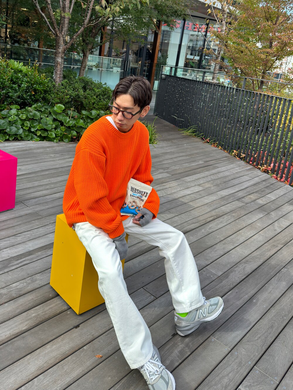 オレンジ系のニット/セーター、ホワイト系のデニムパンツ、ホワイト系のTシャツ/カットソーを着用したメンズの秋コーディネートの3枚目の写真