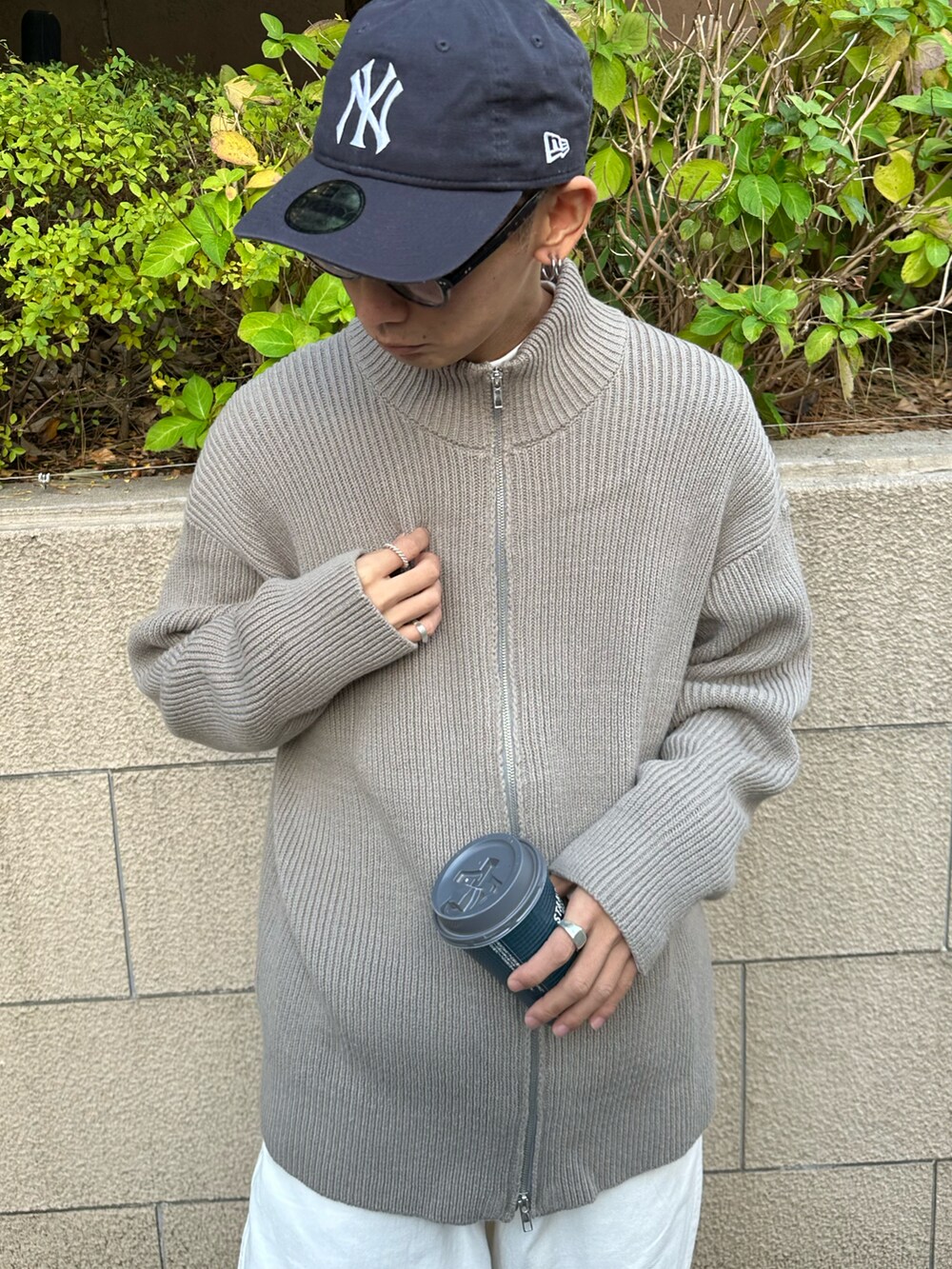 グレー系のカーディガン/ボレロ、ホワイト系のTシャツ/カットソー、ホワイト系のデニムパンツを着用したメンズの冬コーディネートの4枚目の写真