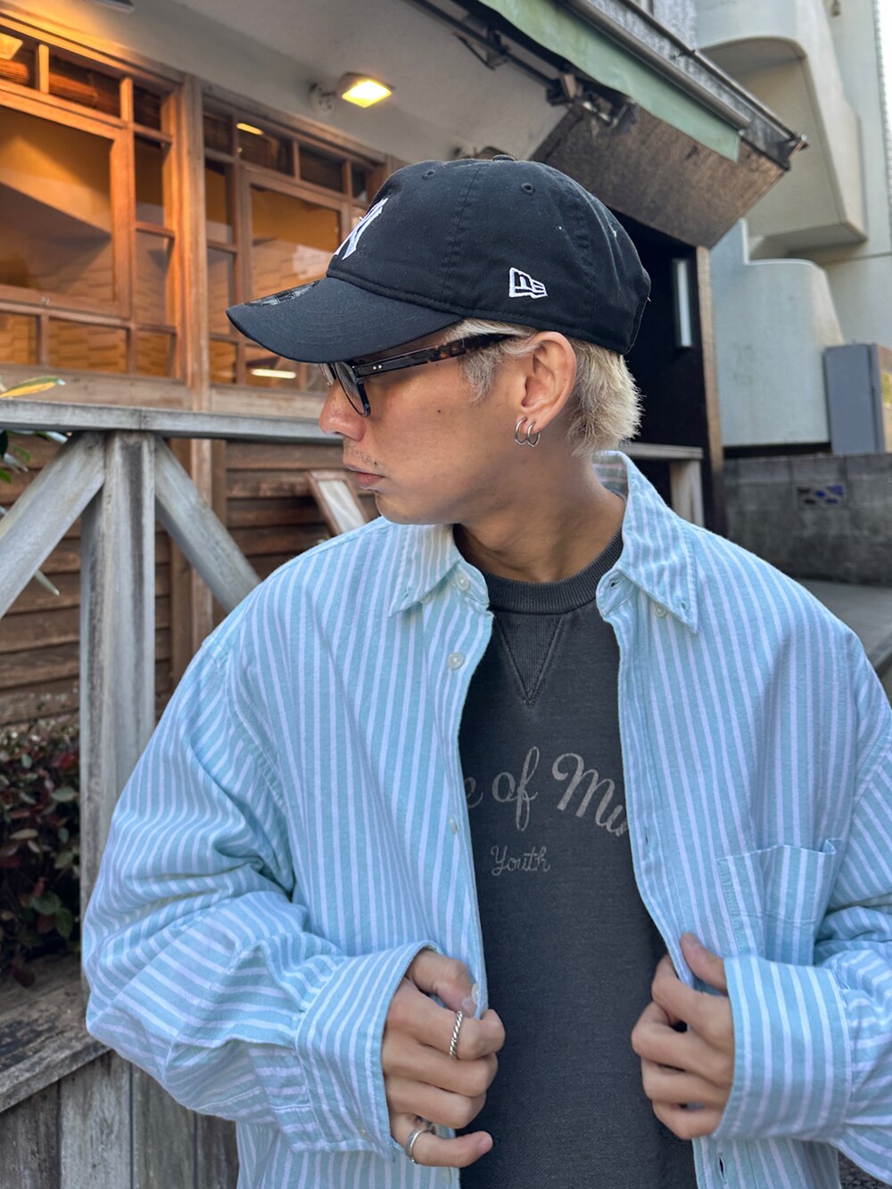 グリーン系のシャツ/ブラウス、ブラック系のスウェット、ホワイト系のスニーカーを着用したメンズの冬コーディネートの3枚目の写真