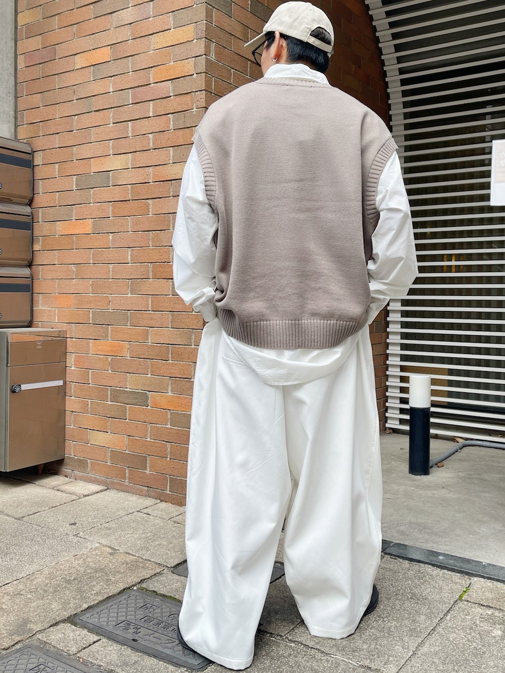 ベージュ系のベスト、ホワイト系のシャツ/ブラウス、ホワイト系のスラックスを着用したメンズの冬コーディネートの2枚目の写真