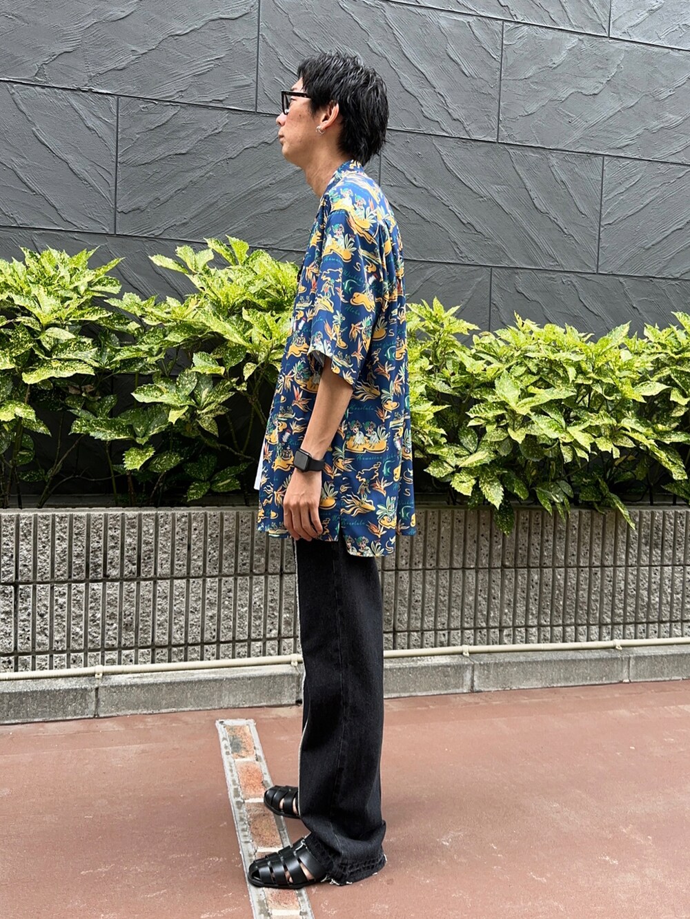 ブラック系のサンダル、ホワイト系のタンクトップ、ブラック系のデニムパンツを着用したメンズの夏コーディネートの2枚目の写真