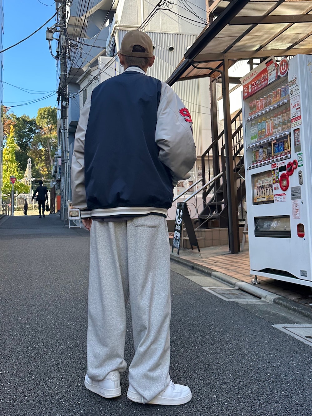 ブルー系のスタジャン、ブラック系のTシャツ/カットソー、ホワイト系のスニーカーを着用したメンズの秋コーディネートの3枚目の写真