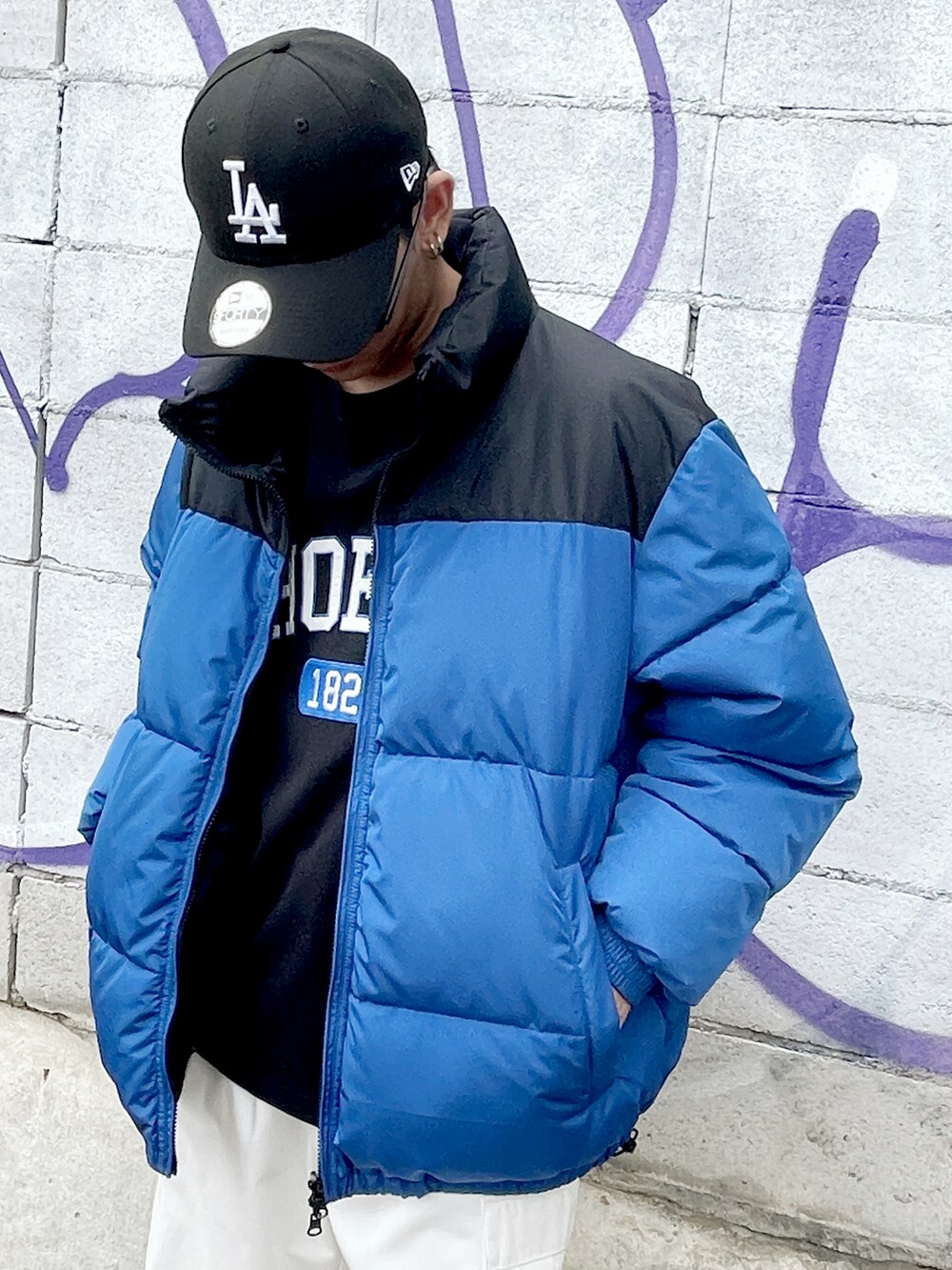 ブルー系のダウンジャケット/コート、ブラック系のTシャツ/カットソー、ホワイト系のカーゴパンツを着用したメンズの夏コーディネートの2枚目の写真