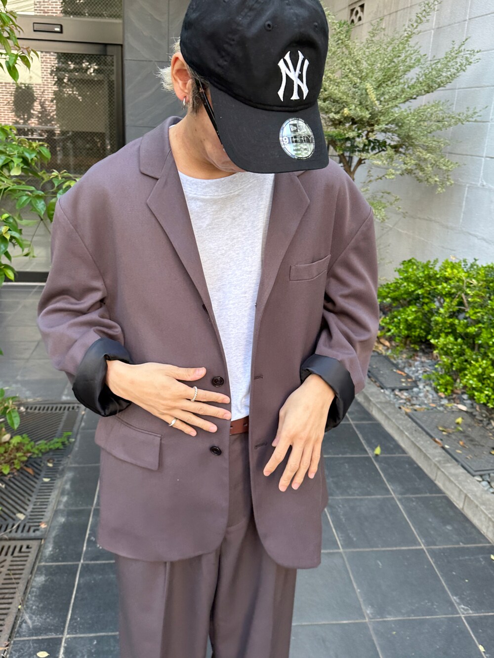 ブラック系のテーラードジャケット、グレー系のTシャツ/カットソー、ホワイト系のスニーカーを着用したメンズの春コーディネートの5枚目の写真